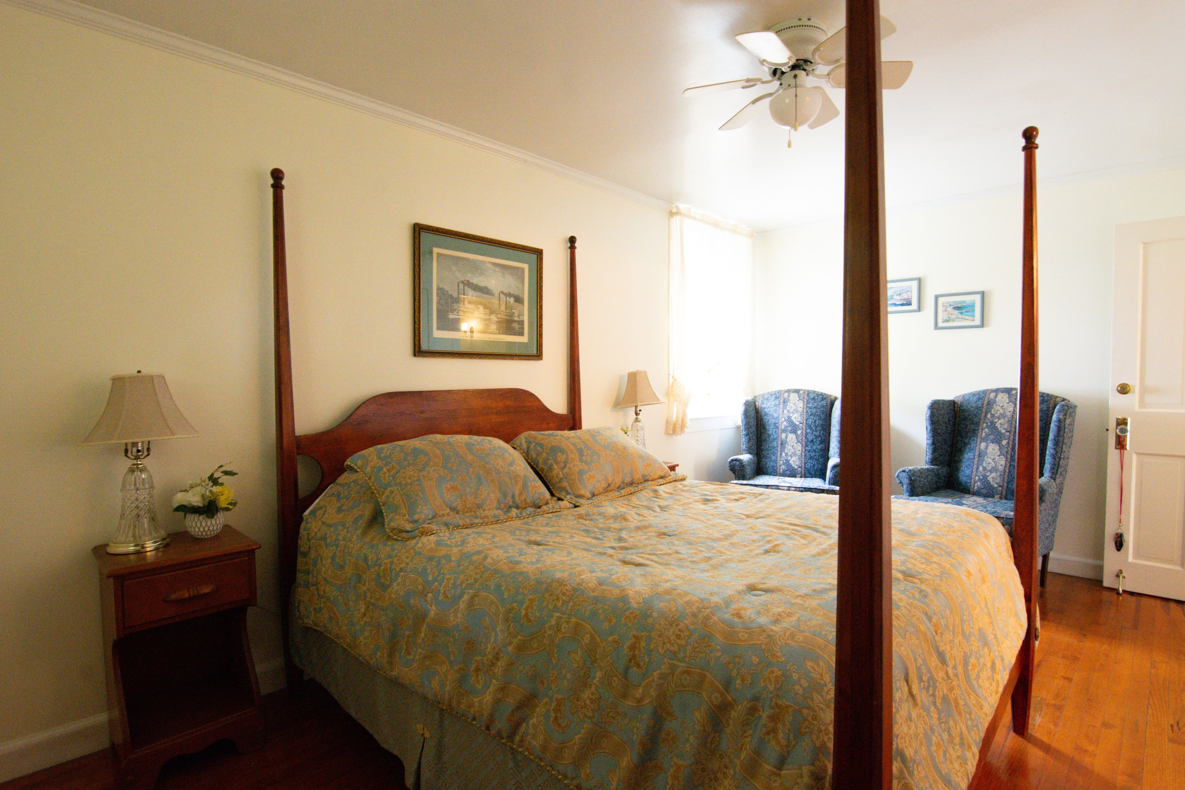 Carriage House room with bed and two armchairs